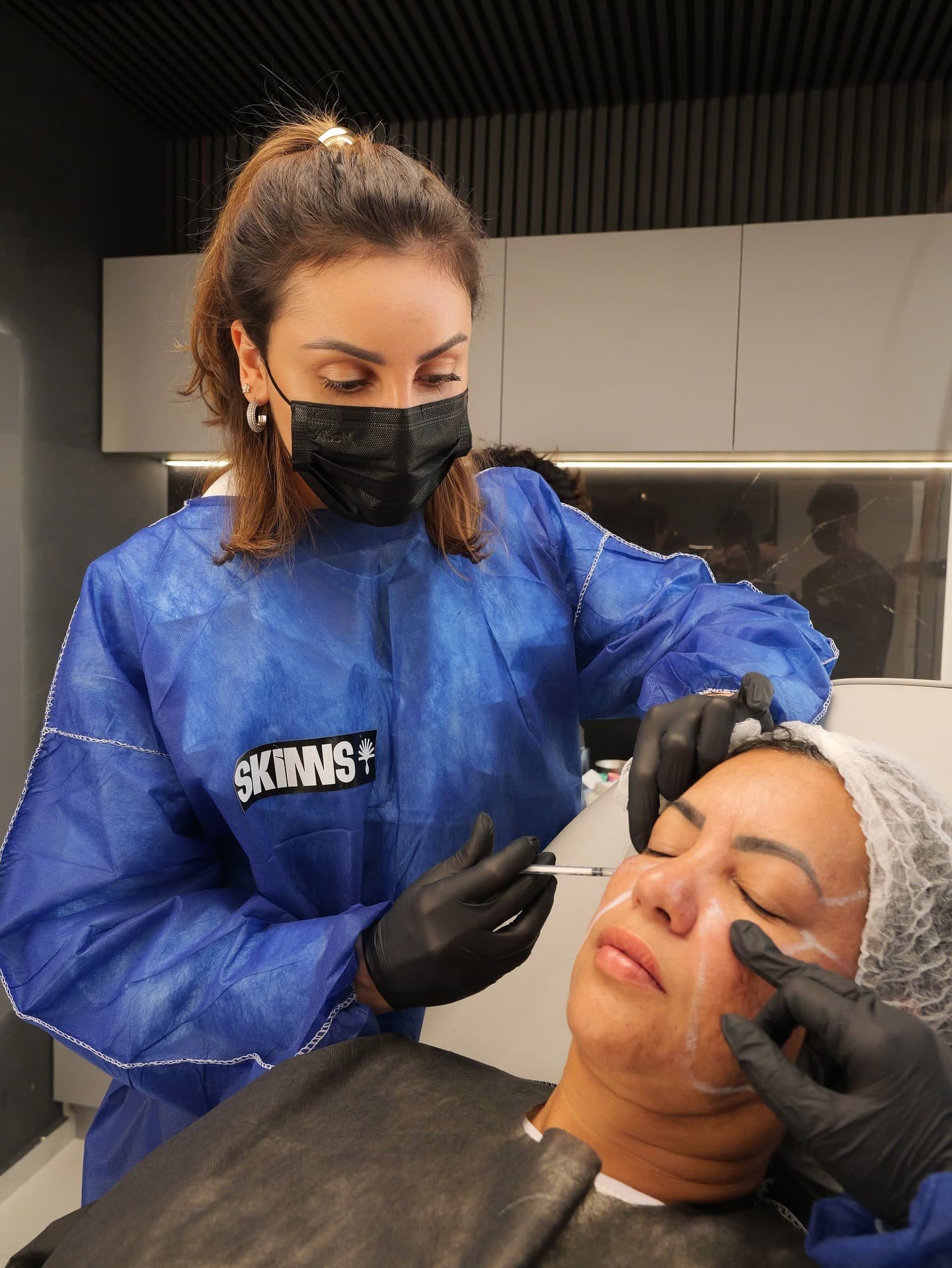 Aluna aplicando o método na região dos olhos, sob supervisão