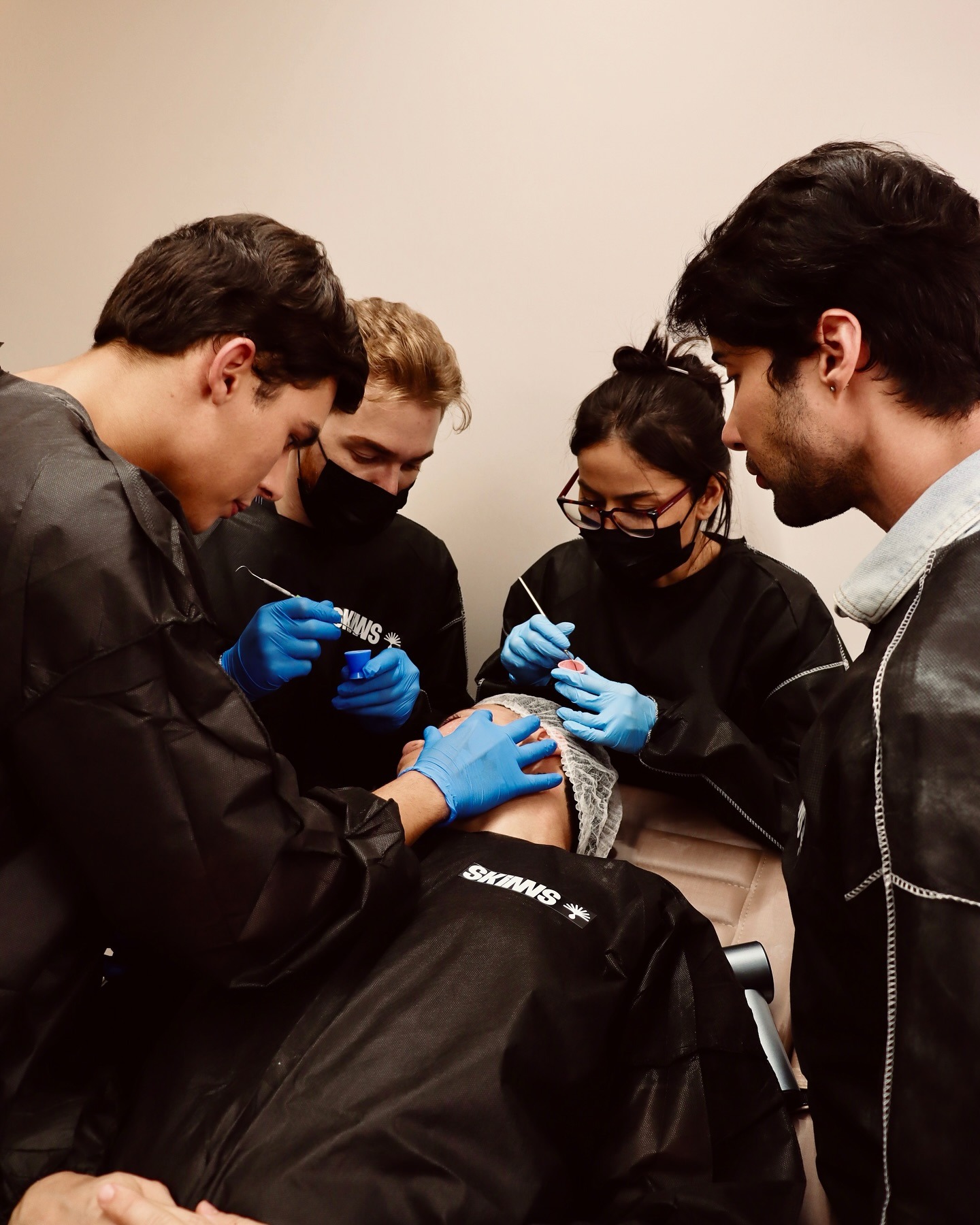 Group of students applying a peel together on a real patient